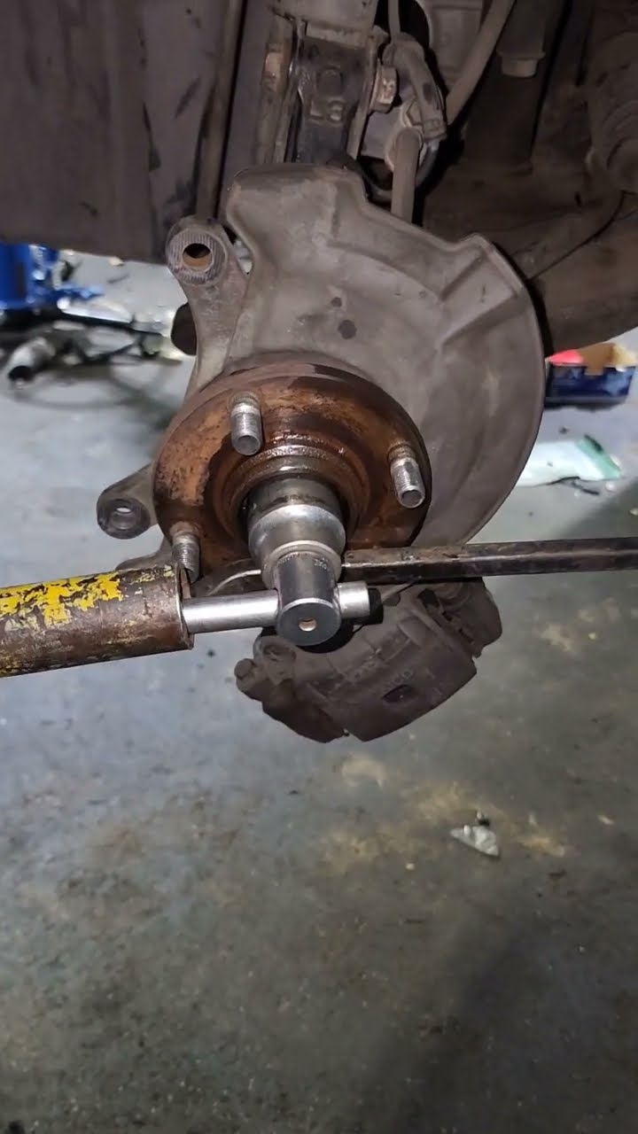 A socket and long-handled tool positioned at an exposed wheel hub.